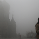 A woman wearing a mask checks her mobile phone during a smoggy day on the square in front of Harbin's landmark San Sophia church, in Heilongjiang province October 21, 2013. The second day of heavy smog with a PM 2.5 index has forced the closure of schools and highways, exceeding 500 micrograms per cubic meter on Monday morning in downtown Harbin, according to Xinhua News Agency. REUTERS/Stringer